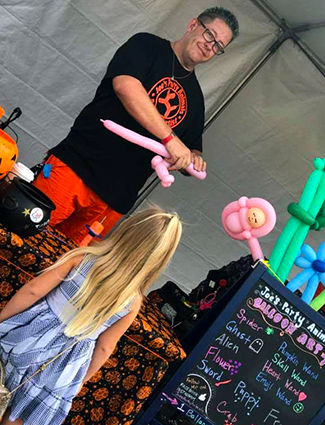Joe of Joe's Party Animals making a balloon for a kid