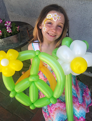 kid with balloons and face painting